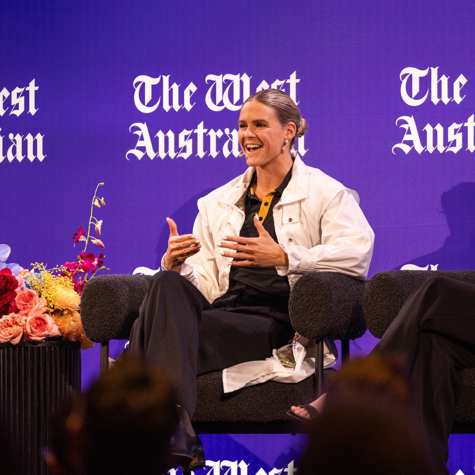 Shayna Jack seated on stage mid-answer during a live conversation event.